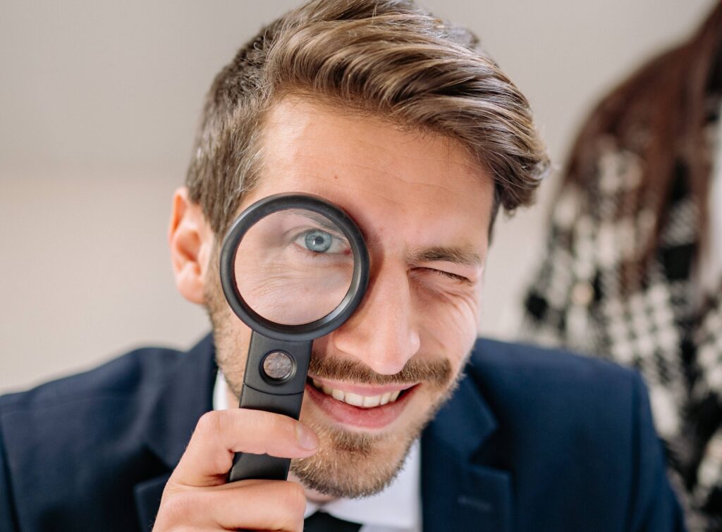 A man holding a magnifying glass to his eyes