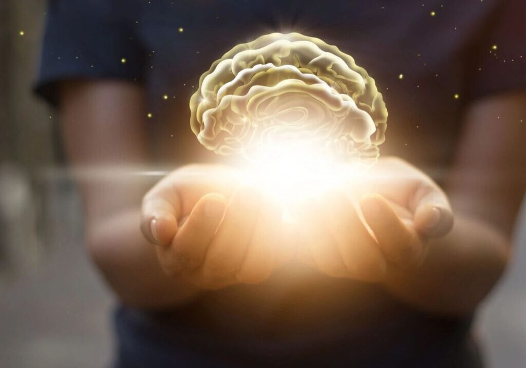 A pair of hands holding an illuminating brain
