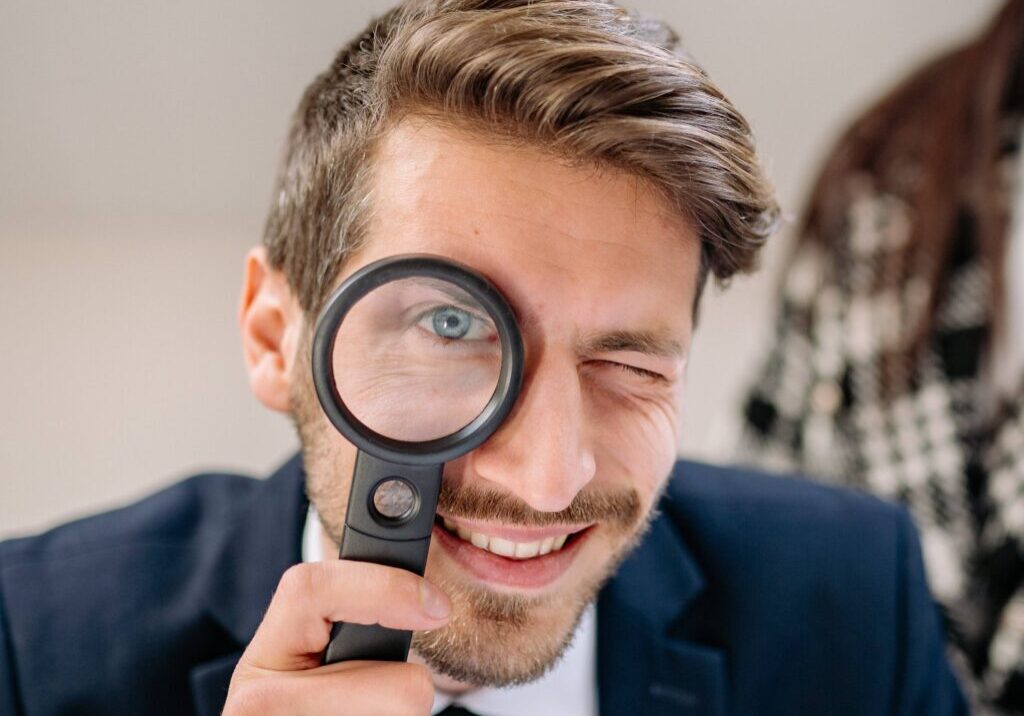 A man holding a magnifying glass to his eyes